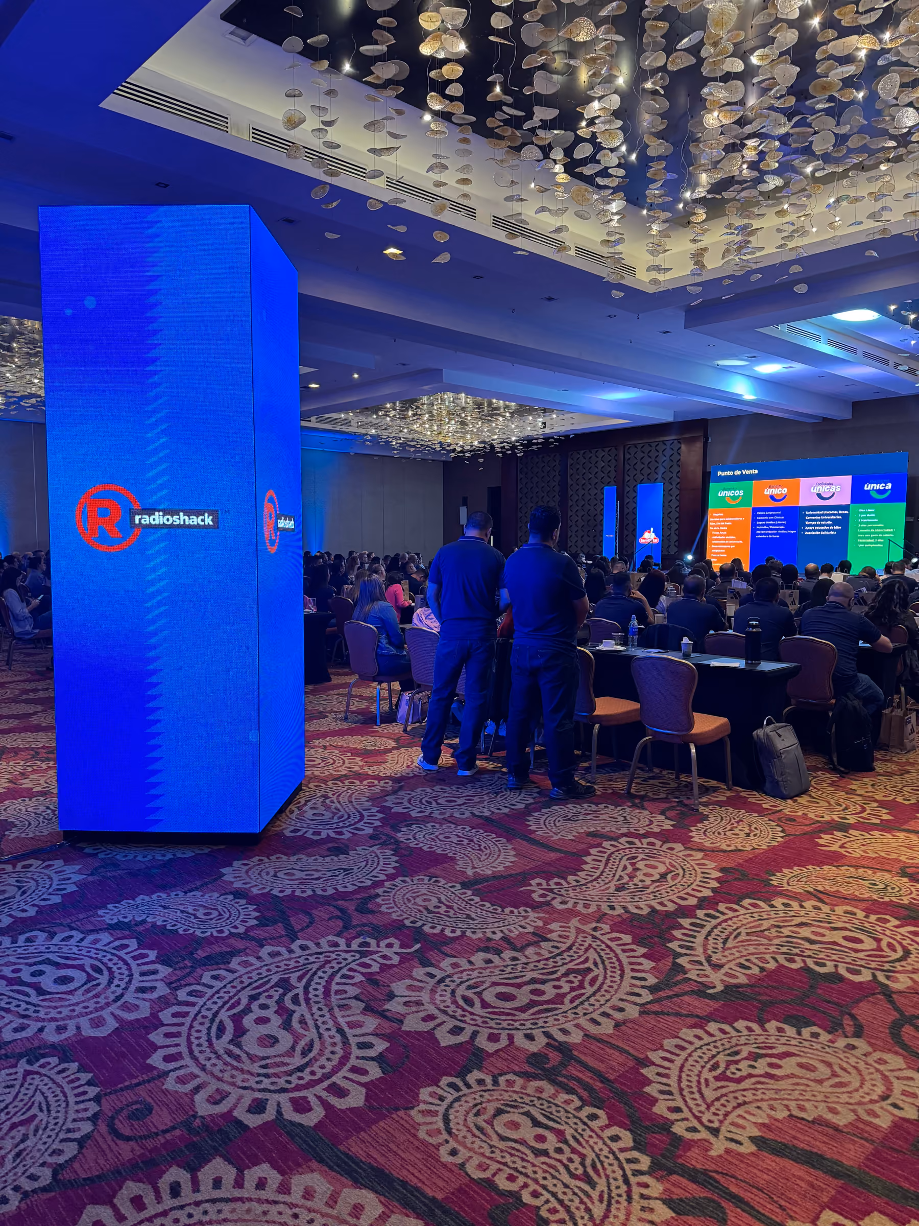 Columna de pantalla LED en un salón de convenciones lleno